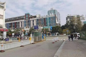 A street view with buildings, a pedestrian crossing, and a few people walking. - Shujie Hotel (Fuzhou)