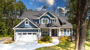 A two-story house with a garage, a front porch, and a driveway.