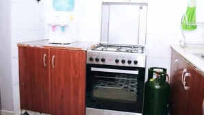 A kitchen with a gas stove, oven, and a water dispenser.