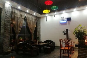 A room with a dining table, chairs, a sofa, and curtains. - Dongxing Jinghui Hotel (Dongxing)