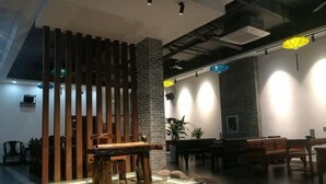 A modern interior with a wooden dining area, stone pillar, and ambient lighting.