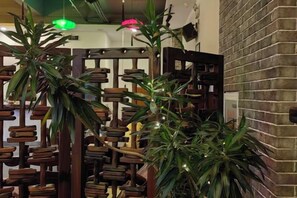 Una habitación con pared de ladrillo, muebles de madera y plantas verdes.