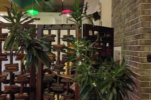 Una habitación con pared de ladrillo, muebles de madera y plantas verdes.