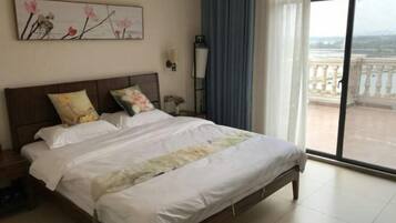 Een hotelkamer met een groot bed, een nachtkastje, een wandlamp en uitzicht op een balkon.