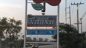 A road sign with '24' and 'est' on it, surrounded by greenery and power lines. - Maingam Resort (Si Prachan)