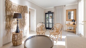 A room with a round table, two wicker chairs, a lamp, a cabinet, and a mirror. - Porto Letizia Viola 1, Porlezza, Italy (Porlezza)