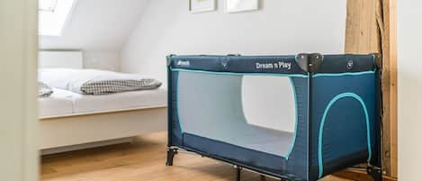 A room with a loft bed, a small trampoline, and a wooden floor.