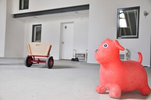 Ein Zimmer mit einem Spielpferd und einem Spielzeugwagen.