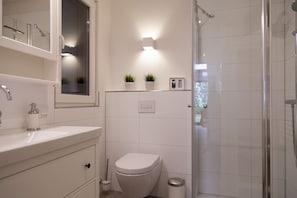 Ein modernes Badezimmer mit Dusche, Toilette und Waschbecken.