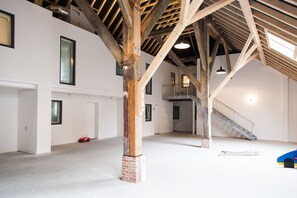 Ein Innenraum mit freiliegenden Holzbalken, einer Treppe und einem roten Spielzeugauto.