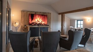 Una sala de estar acogedora con chimenea, asientos cómodos y una zona de comedor.