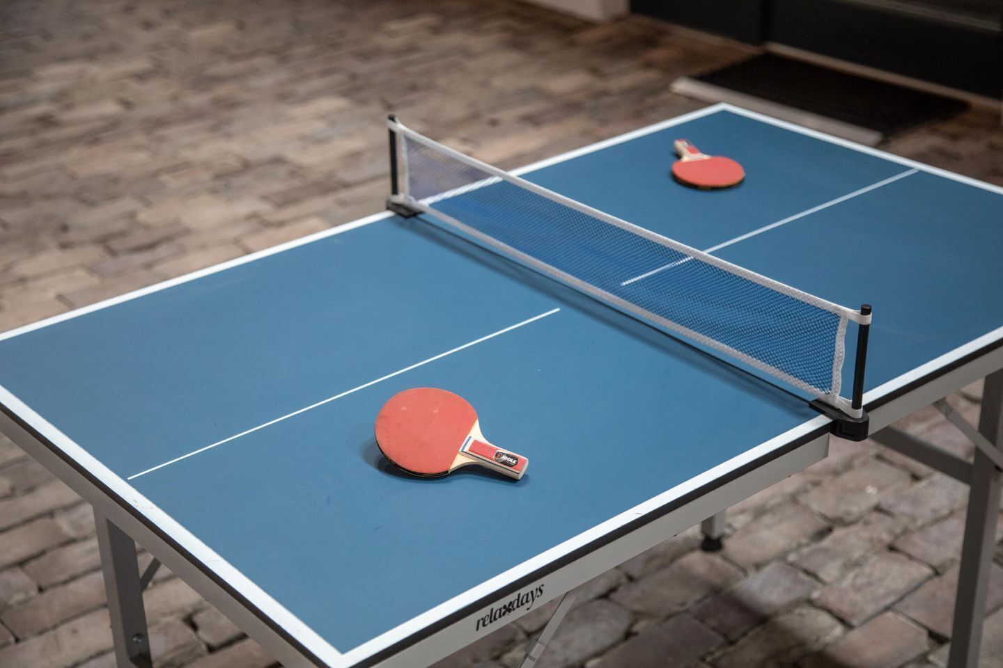 A ping pong table with two paddles and a net.