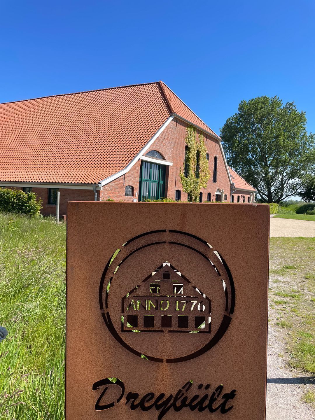 A building with a red-tiled roof and a sign indicating 'Anno 1776' and 'Dreybühl'.
