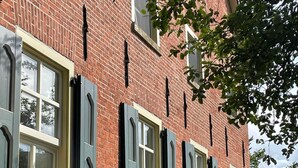 A red brick building with multiple windows and shutters. - Traumhafte Fewo mit Terrasse im Historischen Hof - Gulfhof Boomgaarden (Krummhörn)