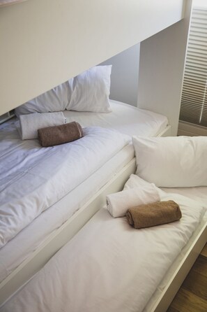 A bunk bed with white bedding and two brown towels placed on the lower bunk. - Moderne und Gemütliche Fewo "gerjet" - Gulfhof Boomgaarden (Krummhörn)