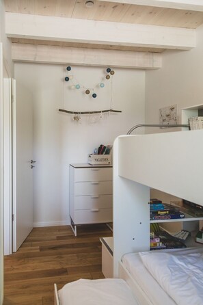 A bunk bed with a white headboard, a desk with a 'MAGAZINES' box, and a wall-mounted decoration. - Moderne und Gemütliche Fewo "gerjet" - Gulfhof Boomgaarden (Krummhörn)