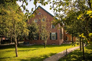 A brick building with a symmetrical facade, multiple windows, and a central entrance.