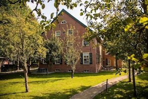 A brick building with a symmetrical facade, multiple windows, and a central entrance.