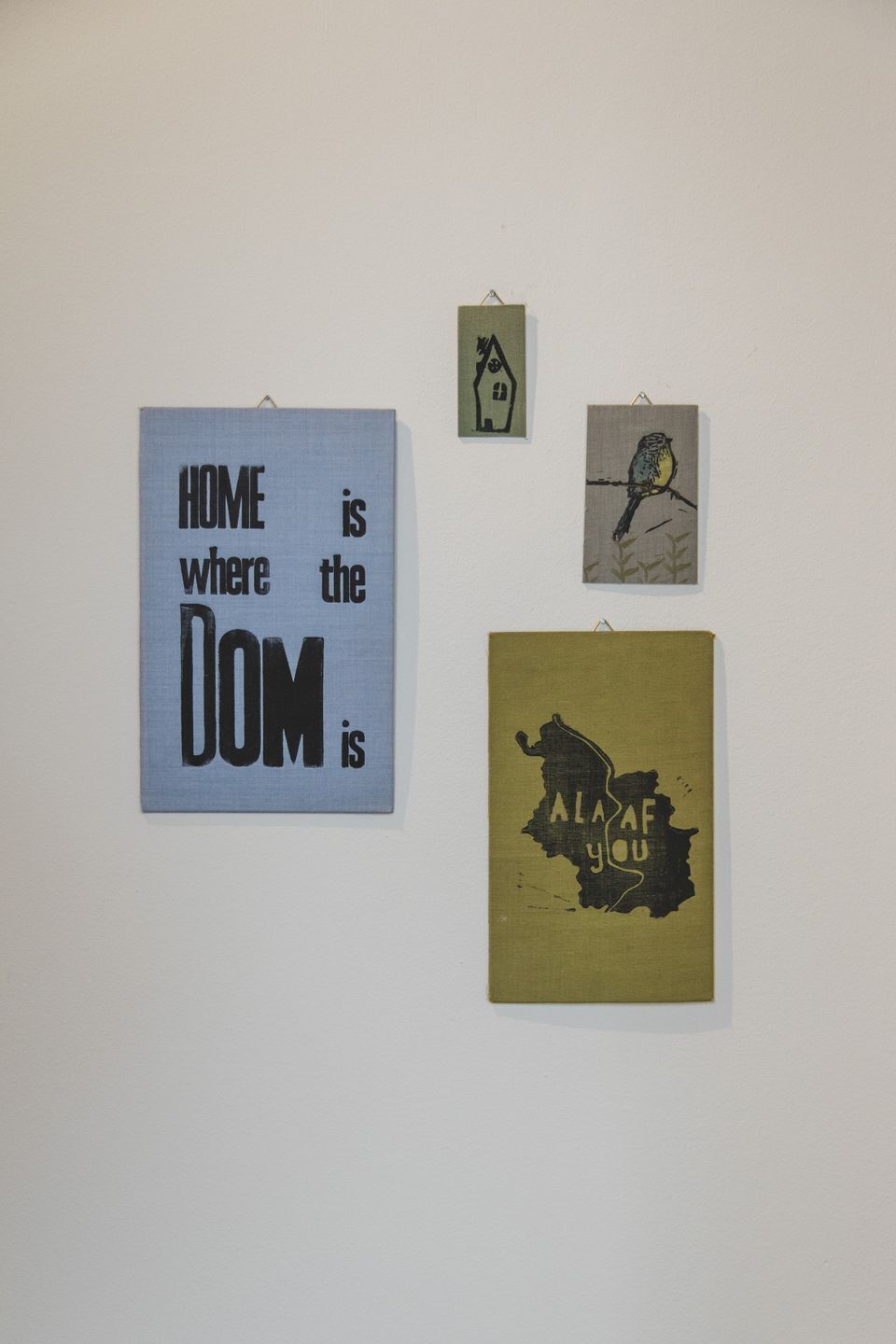 Vier ingelijste kunstwerken aan een muur.