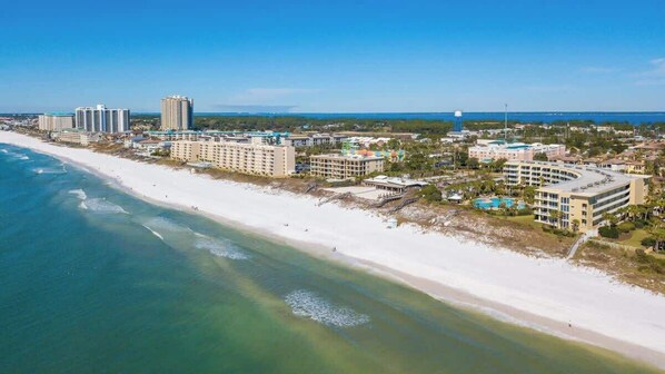 A coastal hotel with multiple buildings, a beach, and a view of the ocean. - The Crescent 207 (Destin)