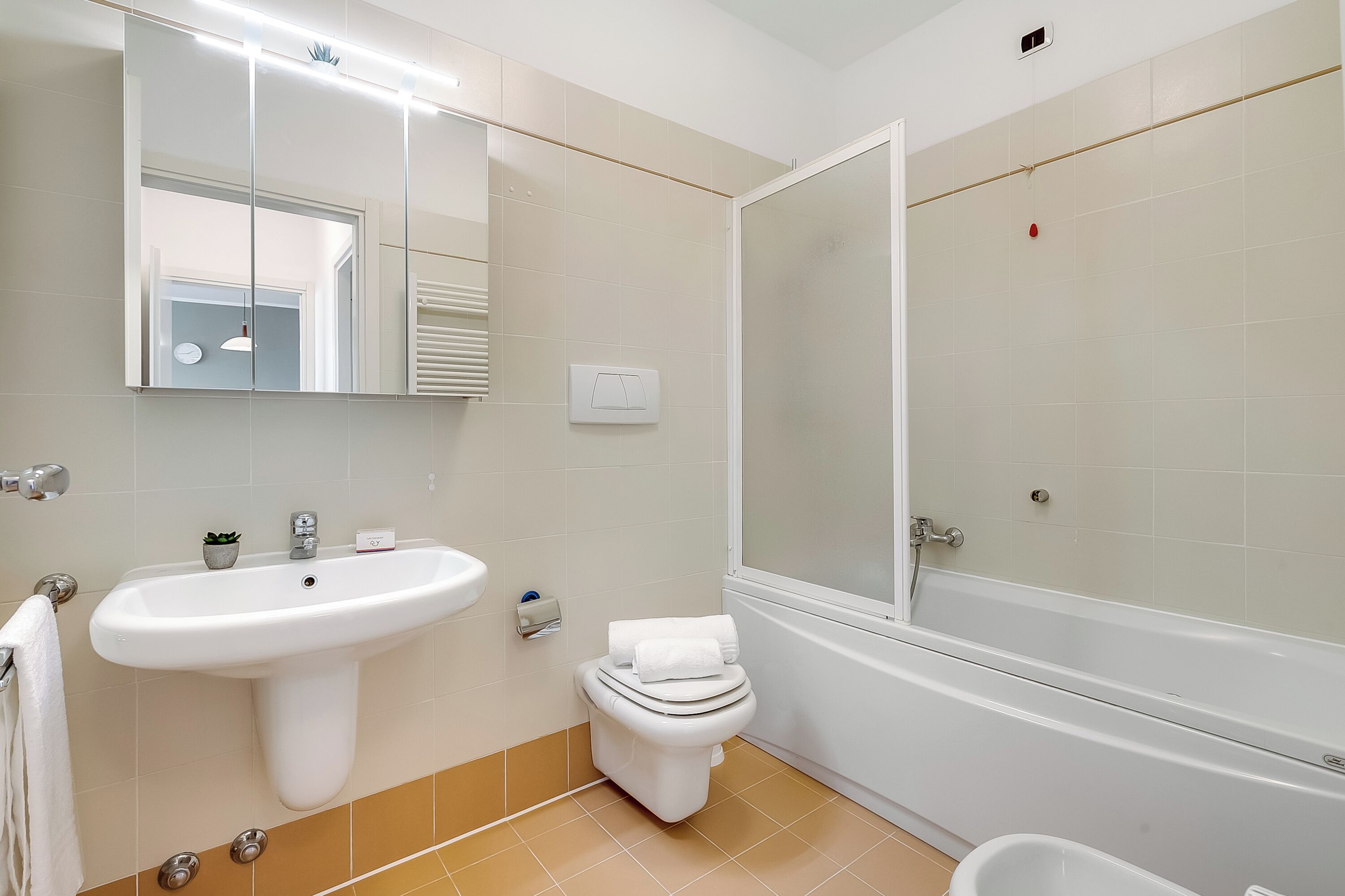 A bathroom with a sink, toilet, and bathtub.