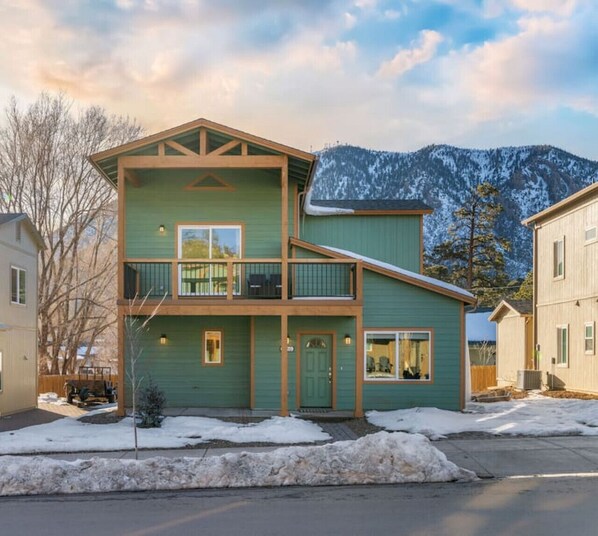 A two-story building with a balcony, a front door, and a view of snow-covered mountains. - Hot Tub*A/C*Mount Elden View* (Flagstaff)
