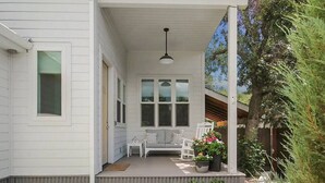 A covered porch with two white chairs, a small table, and potted plants. - White Peak Lodge *Ping-Pong*Pool-Table*PACMAN* (Flagstaff)