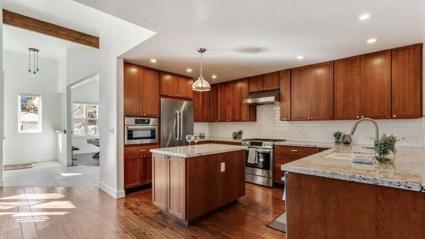 A modern kitchen with wooden cabinets, stainless steel appliances, and a large island. - White Peak Lodge *Ping-Pong*Pool-Table*PACMAN* (Flagstaff)
