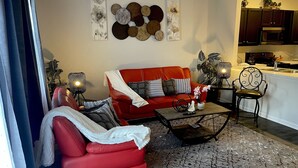 Ein Wohnzimmer mit einem roten Sofa, einem Couchtisch und Wanddekoration.