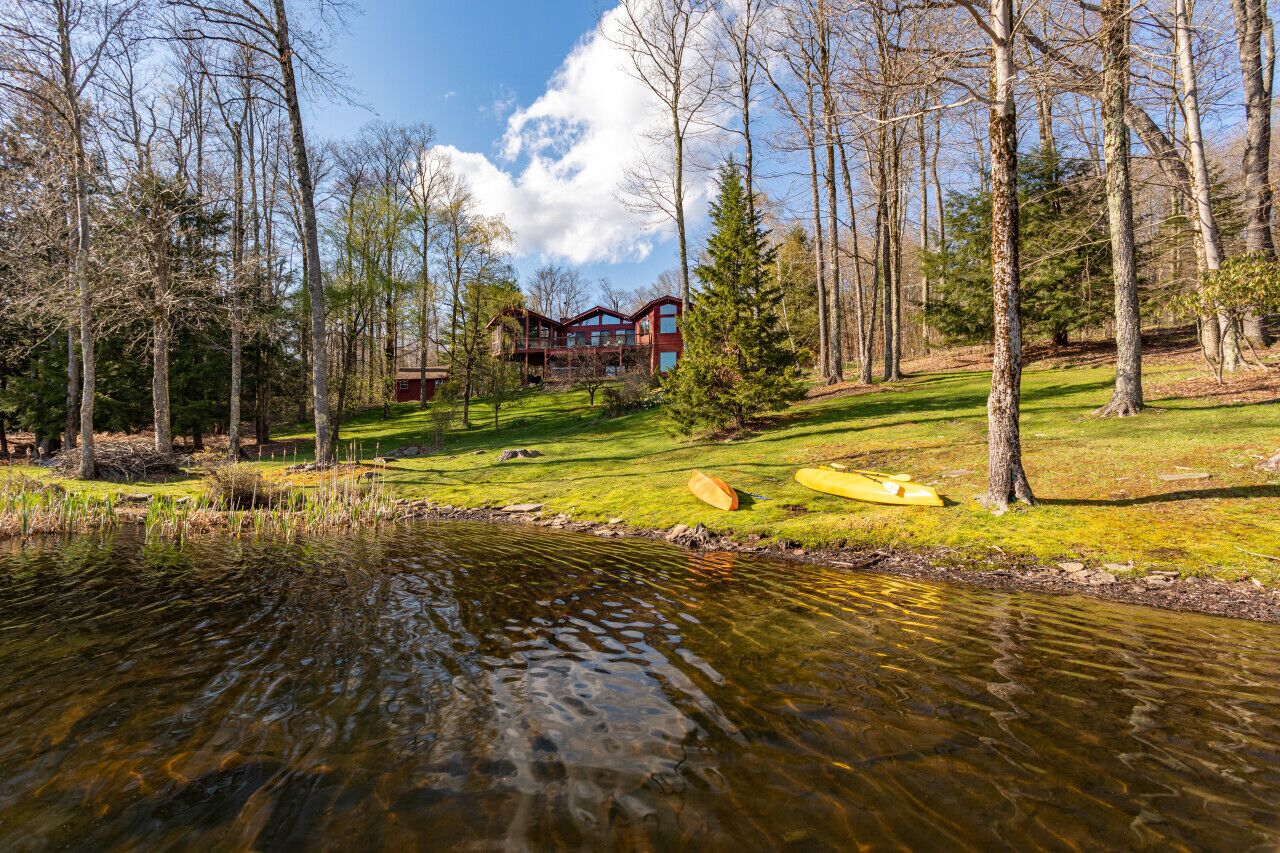 Eine Lodge mit einer großen Holzterrasse und Blick auf einen Fluss.