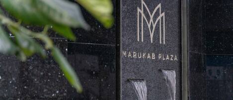 A building entrance with a sign reading "MARUKAB PLAZA" and a logo.