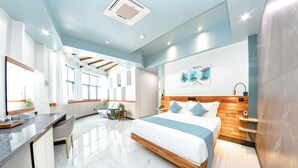 A modern hotel room with a large bed, a desk, and a seating area. - Marukab Plaza (Malé)