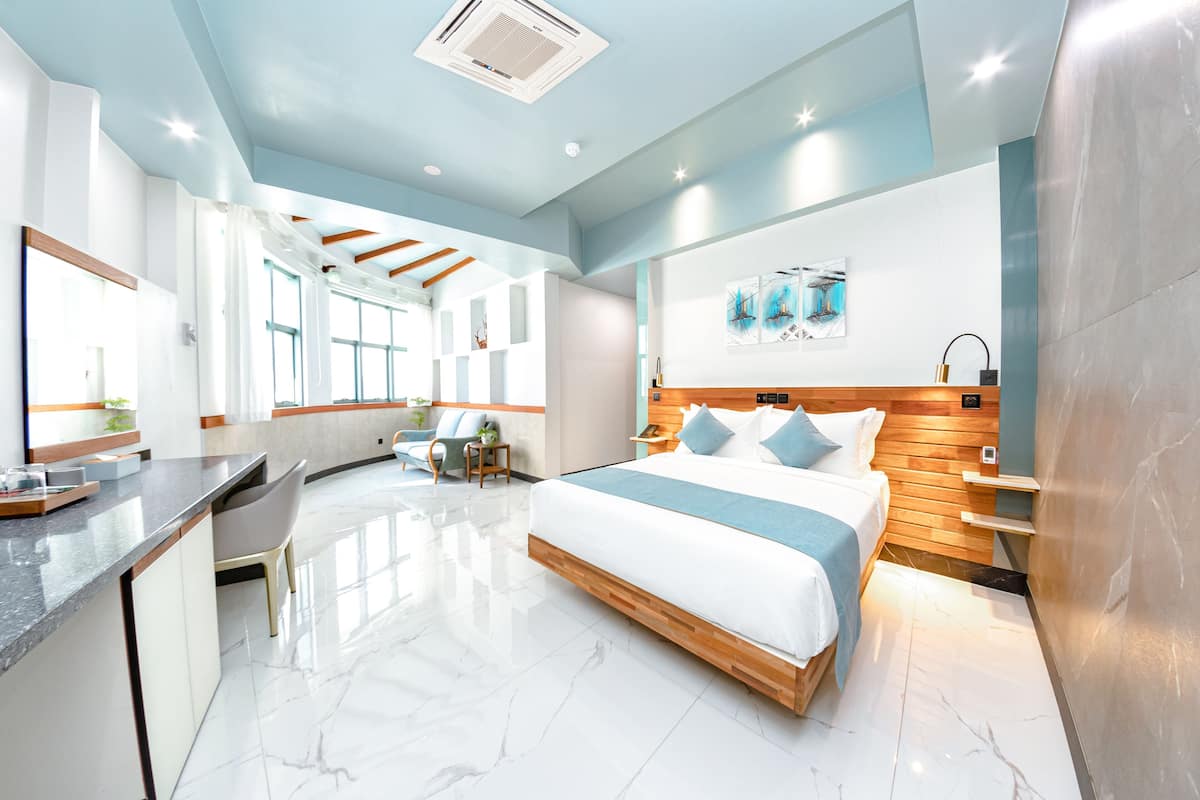 Une chambre d’hôtel moderne dotée d’un grand lit, d’un bureau et d’un coin salon.