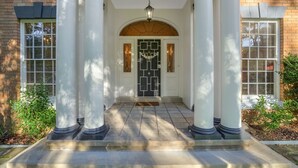 A front entrance with a white door, columns, and a tiled walkway. - Karinya Parkland Estate (New Lambton Heights)