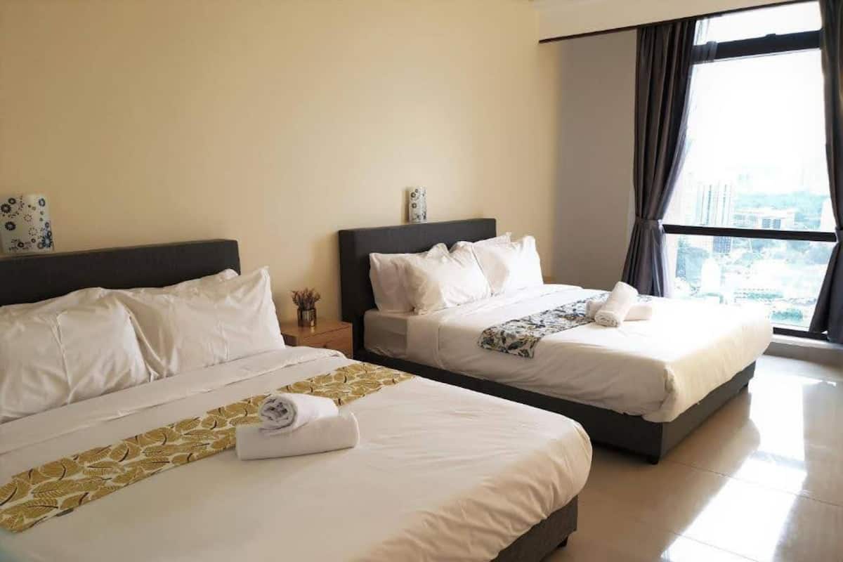 A hotel room with two beds, a large window with a city view, and a clean, modern design.