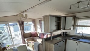 Eine kompakte Küche mit Essbereich, Backofen und einem Fenster mit Jalousien.