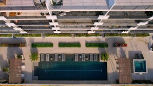An aerial view of a modern building with a rooftop pool, multiple balconies, and outdoor seating areas. - Bahía #304, Sabina Residences (Cabo San Lucas)