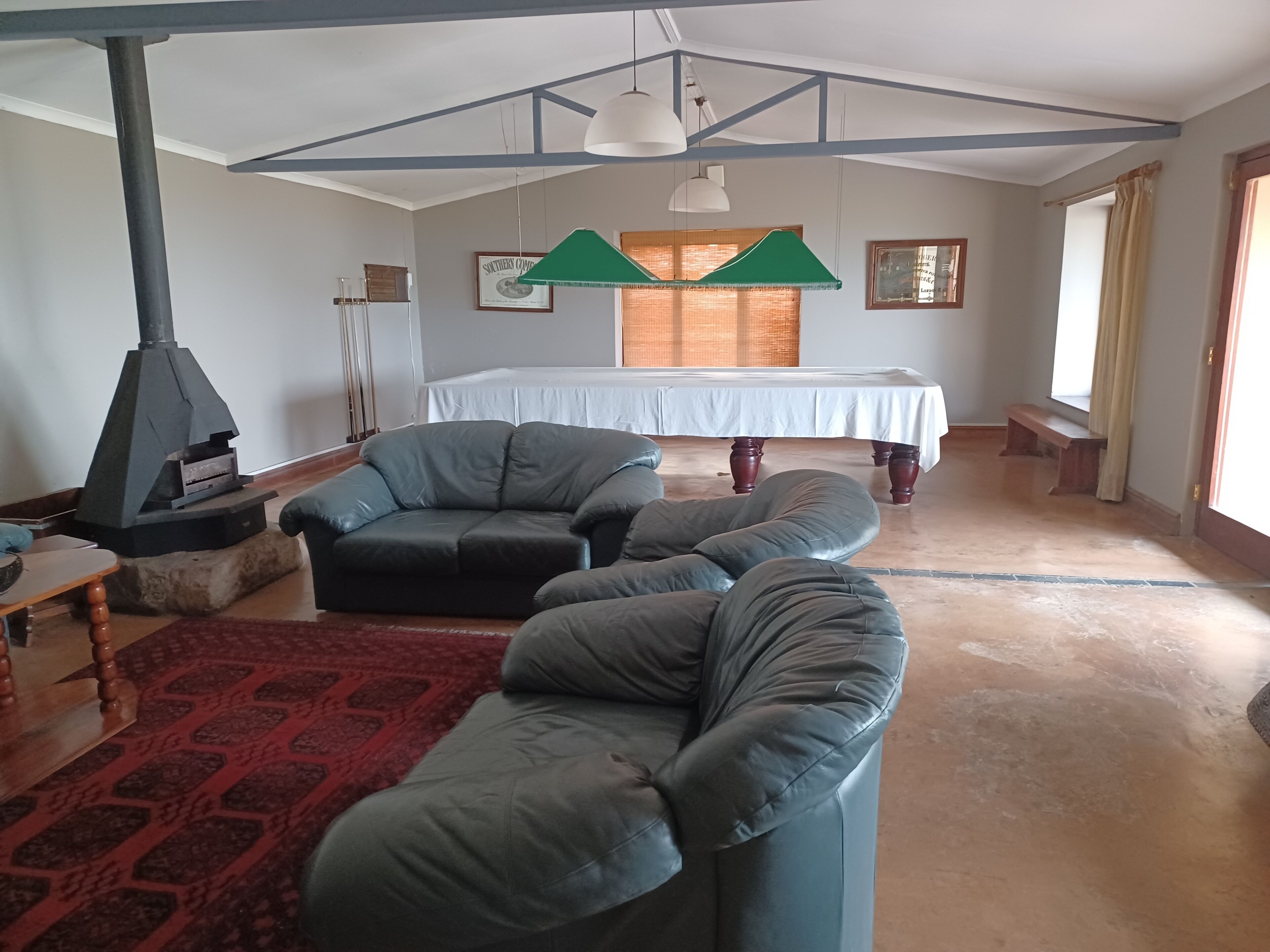 A living room with a sofa, a table, a fireplace, and a bed with a canopy.