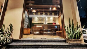 A hotel entrance with a reception desk, a clock, and a sign indicating a reception area. - Hotel 21 Chandigarh (Chandigarh)