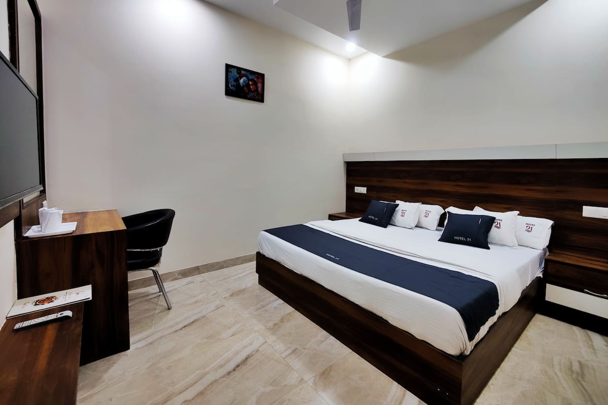 Ein Hotelzimmer mit Bett, Schreibtisch, Stuhl und Deckenventilator.