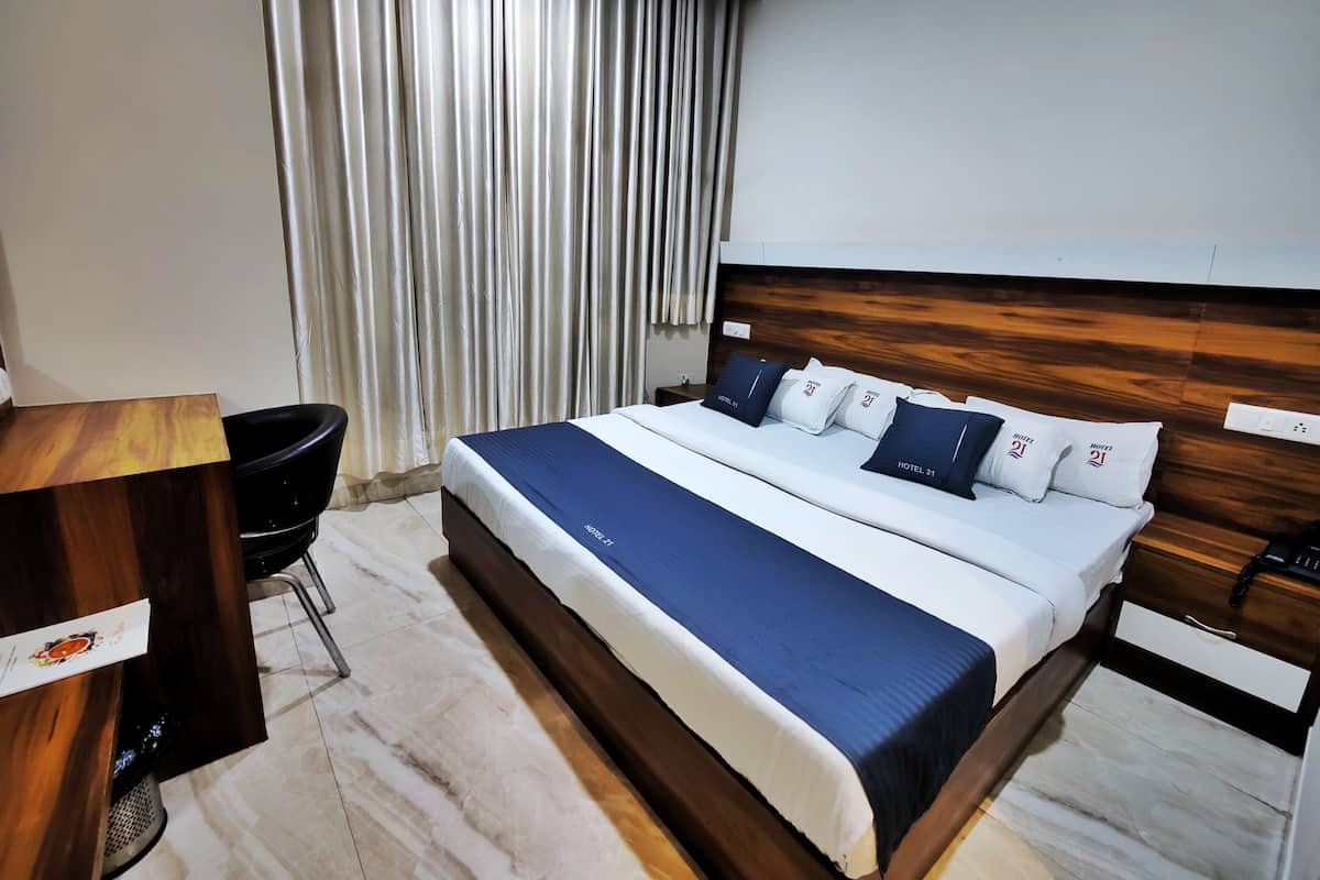 Ein Hotelzimmer mit Bett, Schreibtisch und Stuhl.