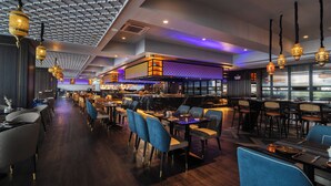 A modern restaurant with a variety of seating options, including tables and chairs, and a bar area. - Bertam Resort and Water Park Penang (Kepala Batas)