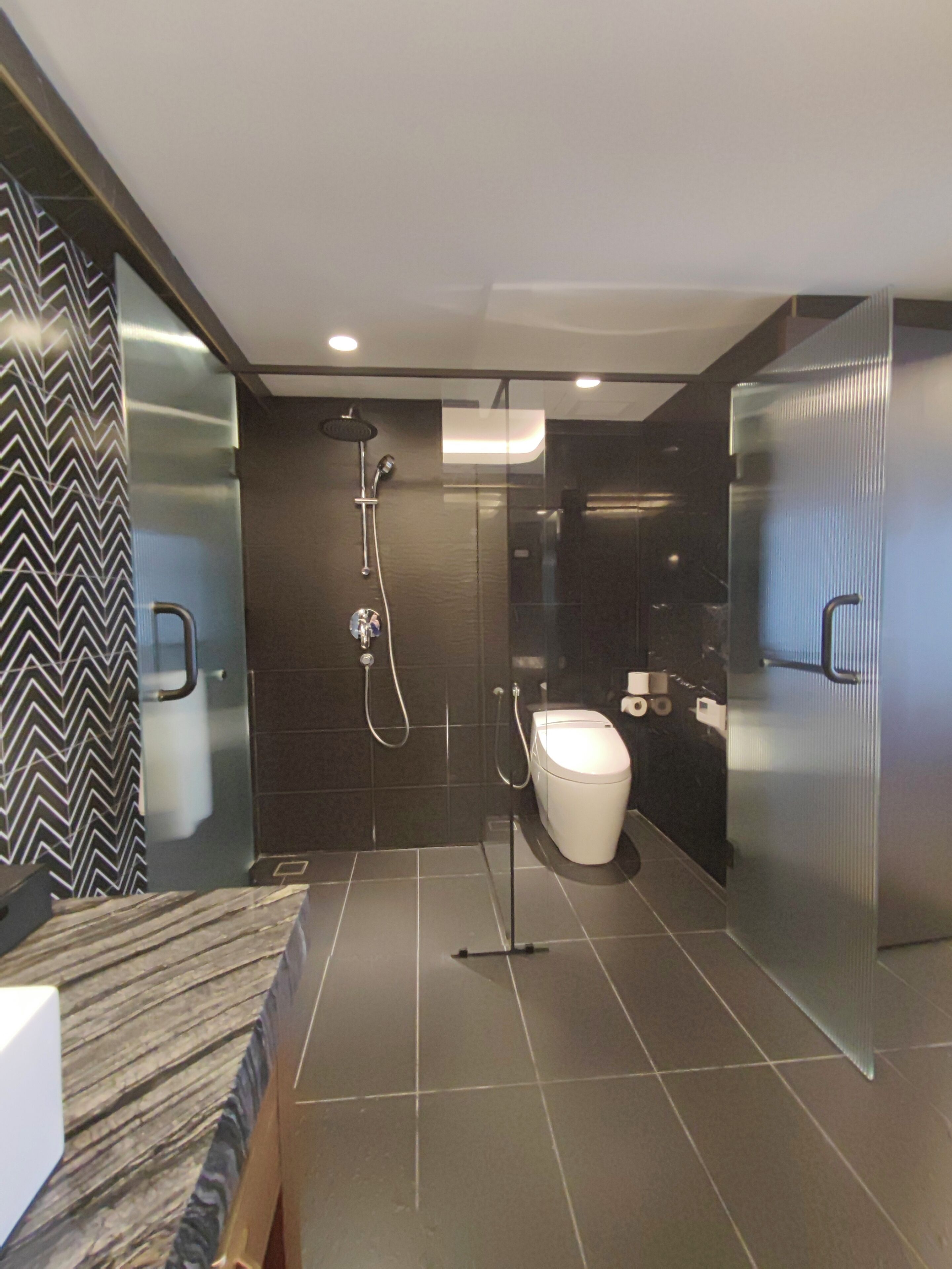 Une salle de bain moderne équipée d’une douche, de toilettes et d’un lavabo.