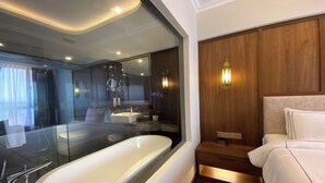 A modern bathroom with a freestanding bathtub, a vanity with a mirror, and a wooden panel wall. - Bertam Resort and Water Park Penang (Kepala Batas)
