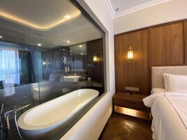 A modern bathroom with a freestanding bathtub, a vanity with a mirror, and a wooden panel wall.