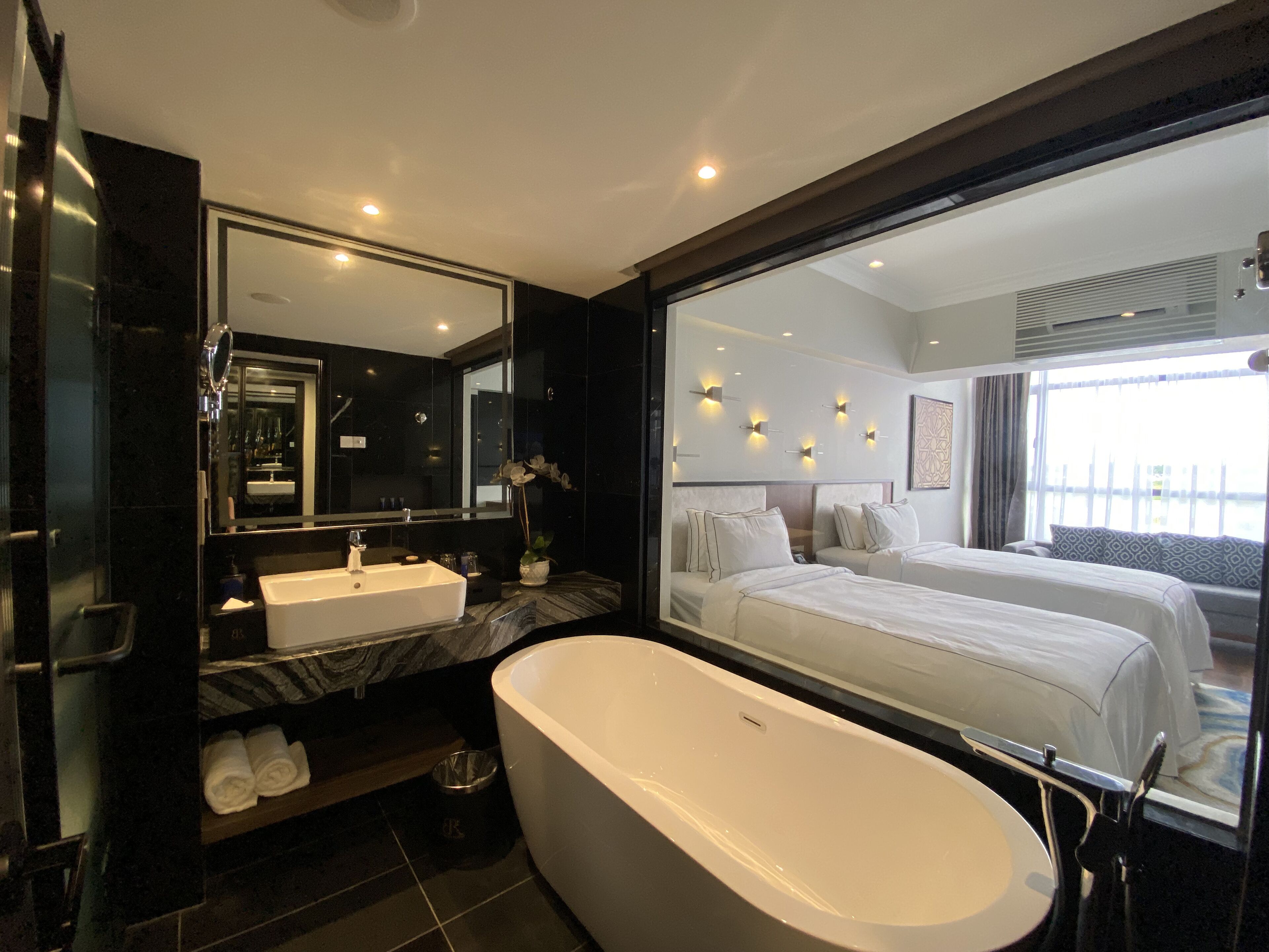 Un baño moderno con una bañera grande, un tocador con doble lavabo y un espejo amplio.