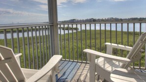 A balcony with a view of a body of water and a distant shoreline. - Pet Friendly, 2nd Floor, 2 BD, 2 BA Condo w/ Bayside Views, Steps to Pool, Tennis, Biking, and More! (Ocean View)