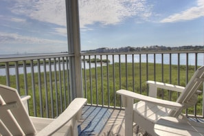 A balcony with a view of a body of water and a distant shoreline. - Pet Friendly, 2nd Floor, 2 BD, 2 BA Condo w/ Bayside Views, Steps to Pool, Tennis, Biking, and More! (Ocean View)