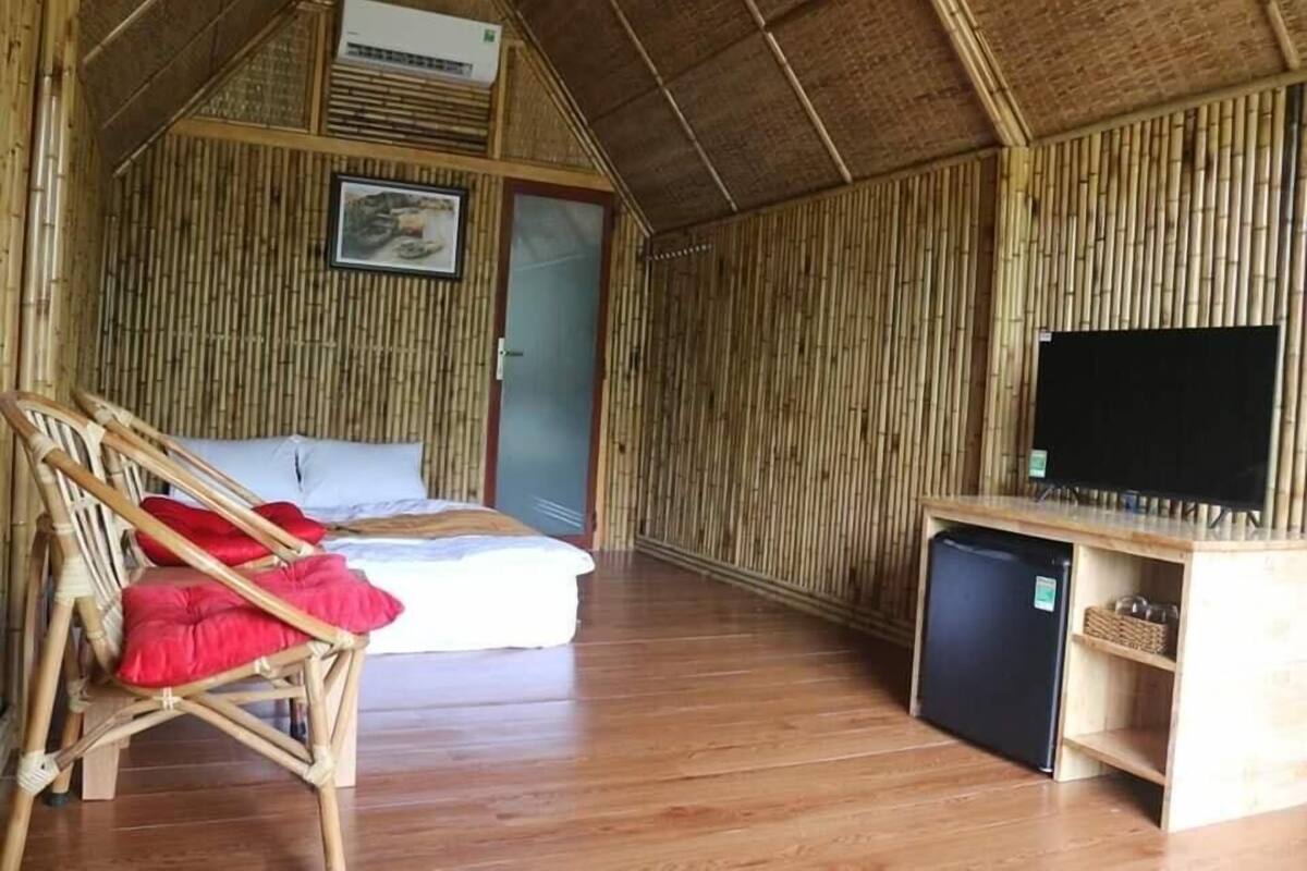 A room with a bed, a chair, a television, and a small refrigerator.