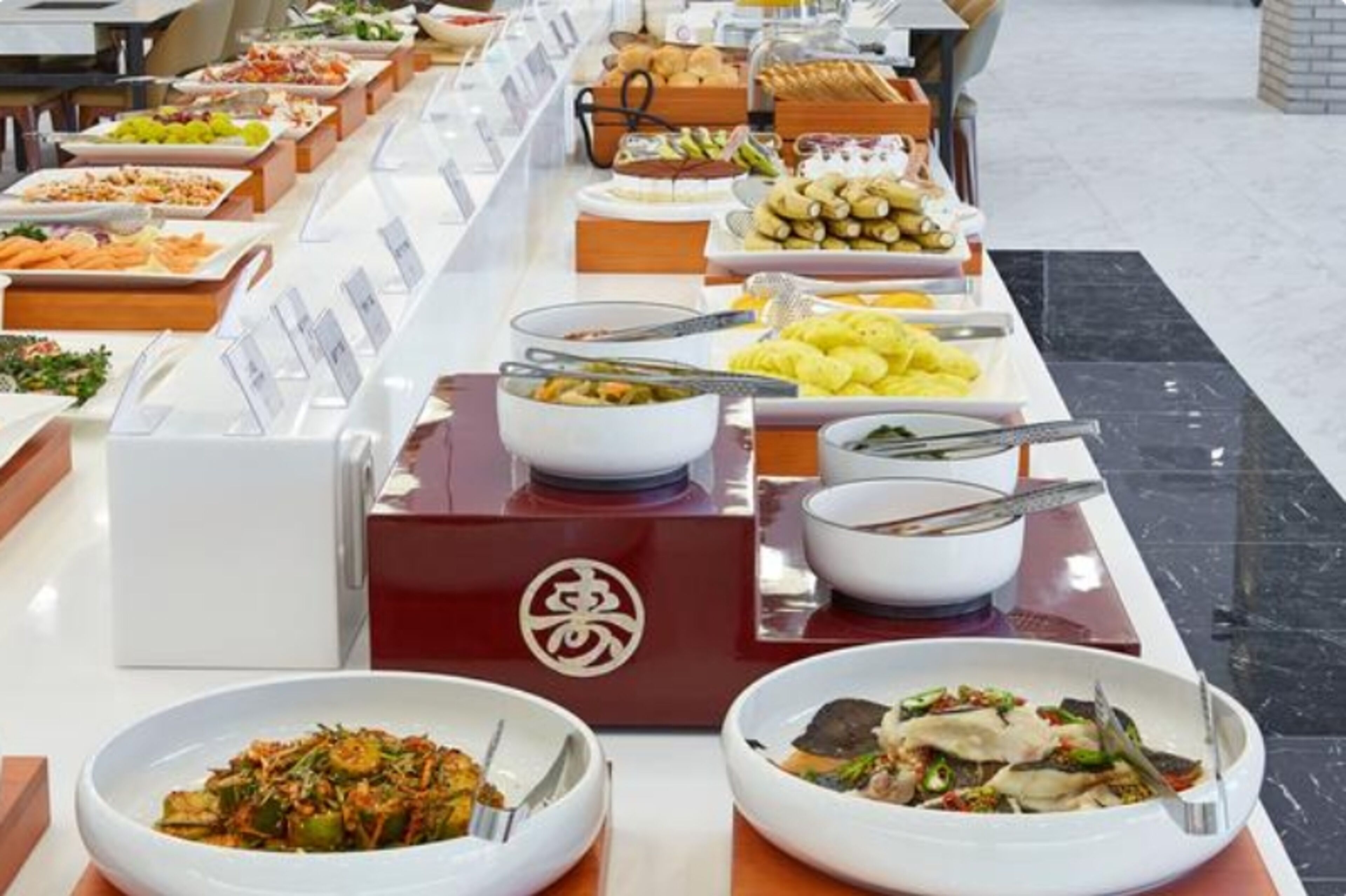 Un buffet proposant divers plats et une boîte rouge ornée d’un logo.